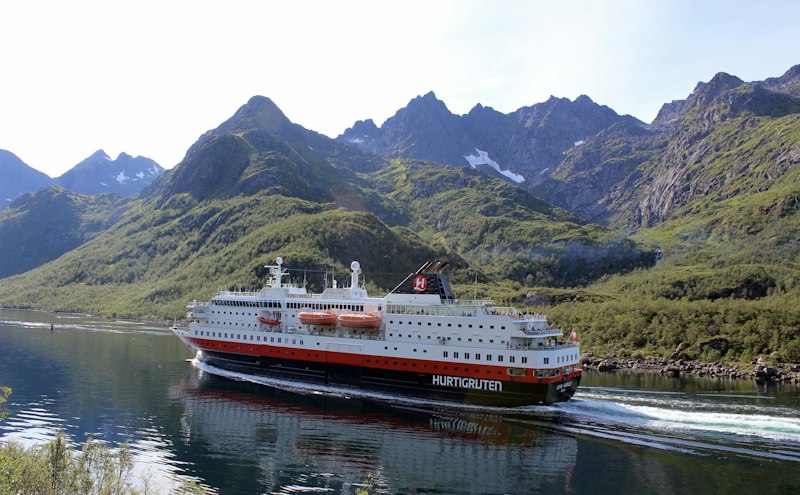 A Hurtigruten ship sailing through a Lofoten fjord