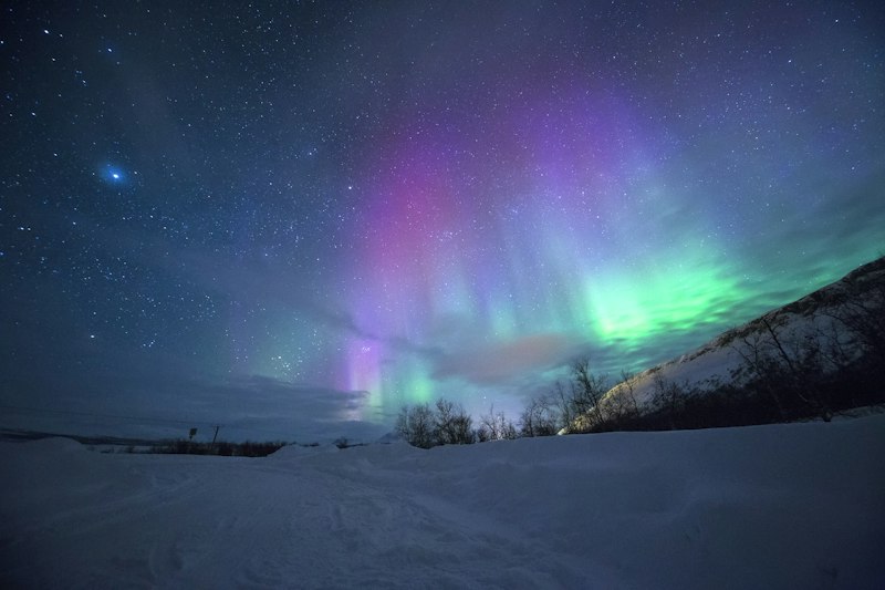Northern lights over snow-covered mountains