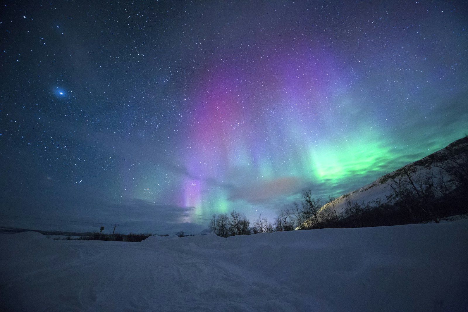 Northern lights over snow-covered mountains
